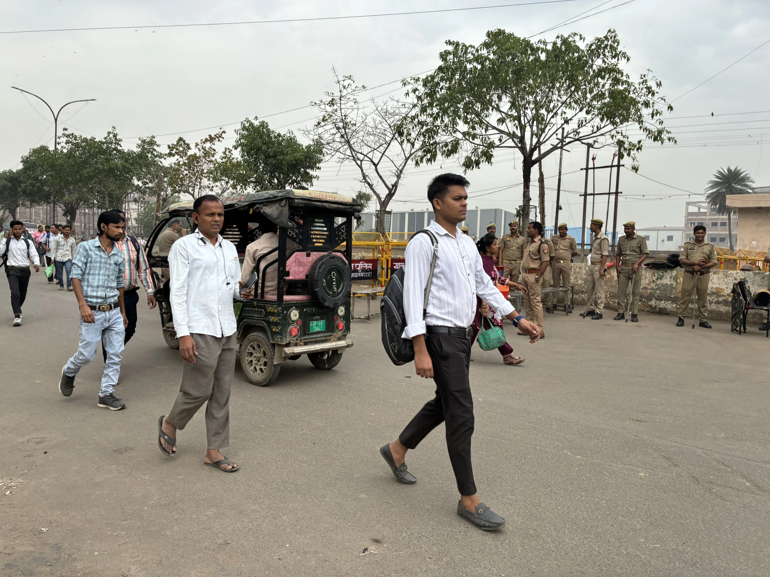 Workers walk to factories past police